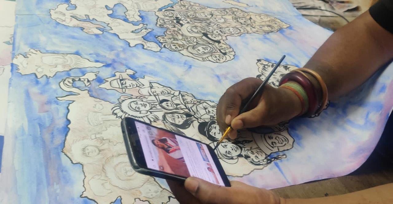 Hand drawing faces on the world map while referencing a phone