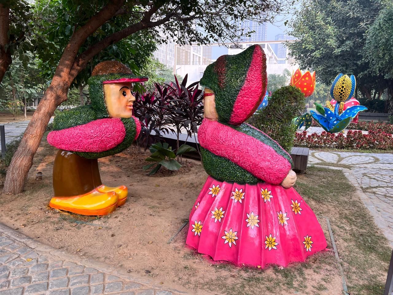 Topiary figures of a couple in traditional dress, with pink and green finishes