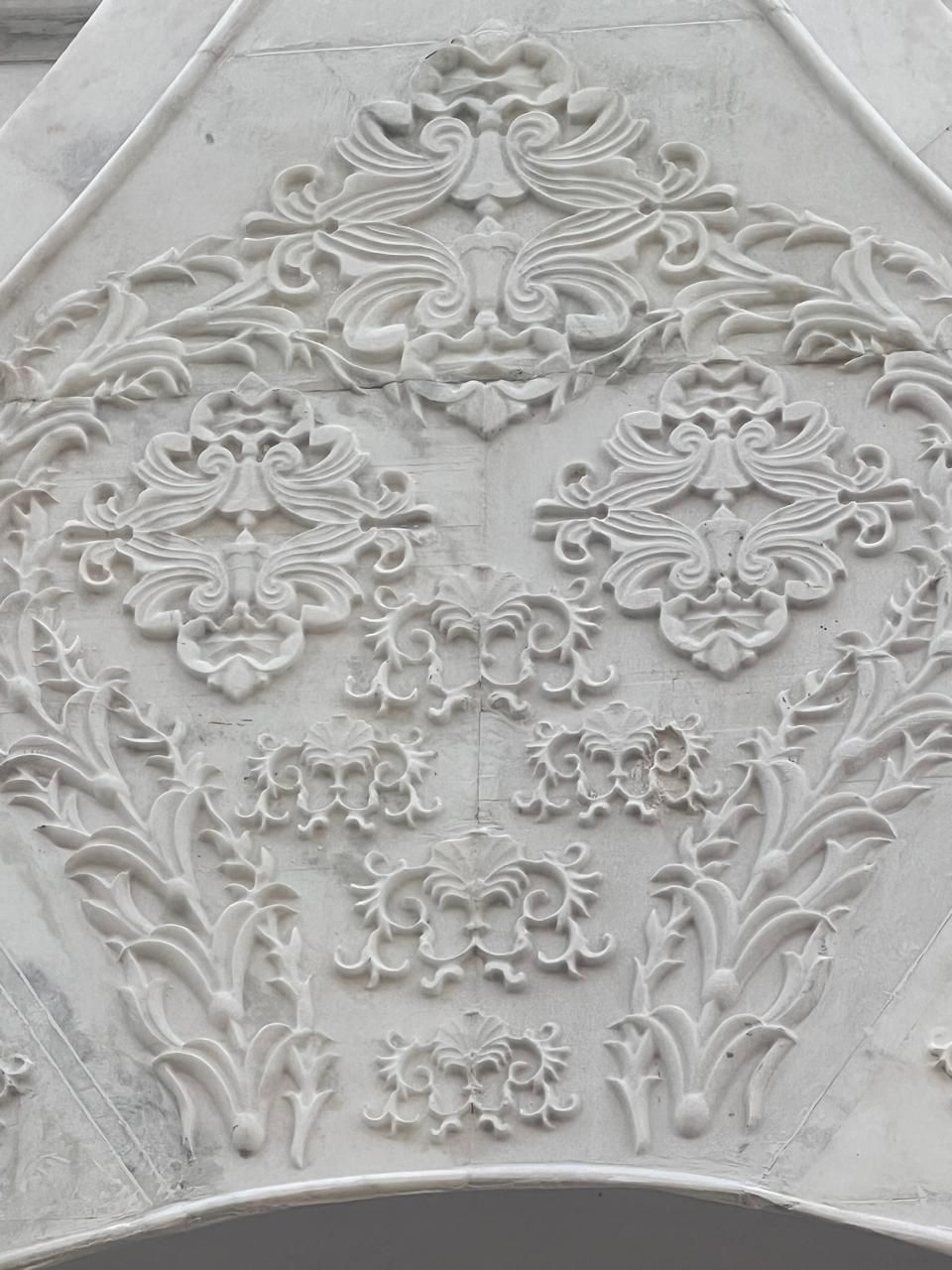 Close view of the floral relief carved into the marble gable