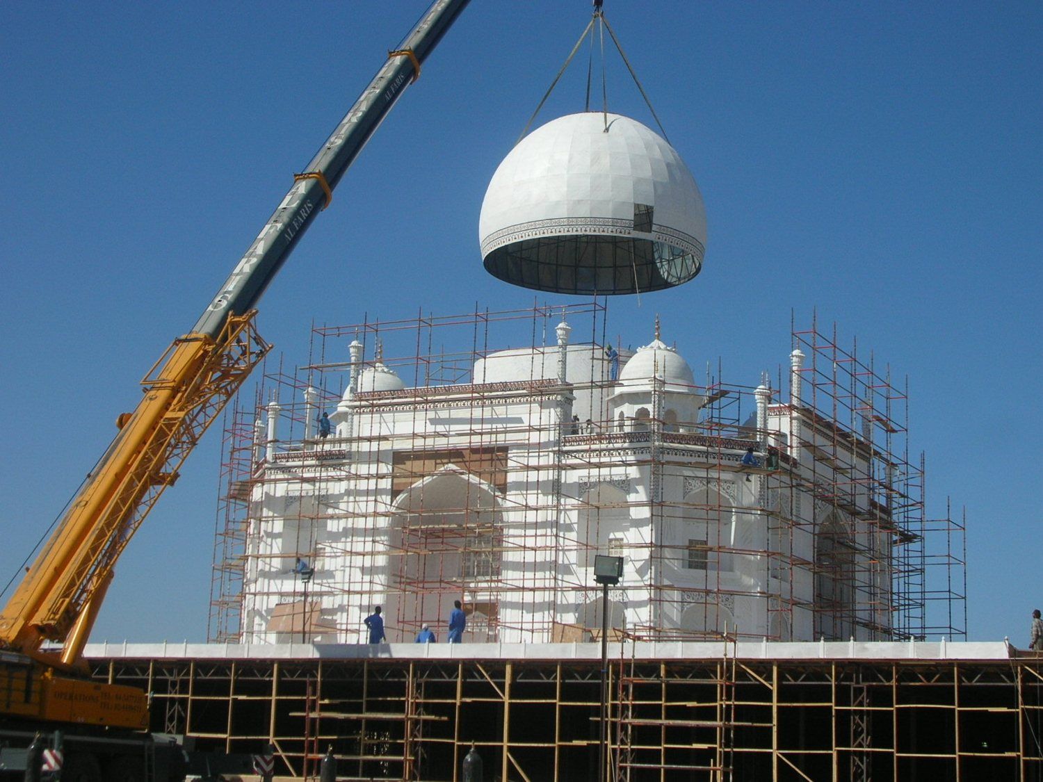 Crane lifting the main dome over the scaffolded Taj Mahal replica