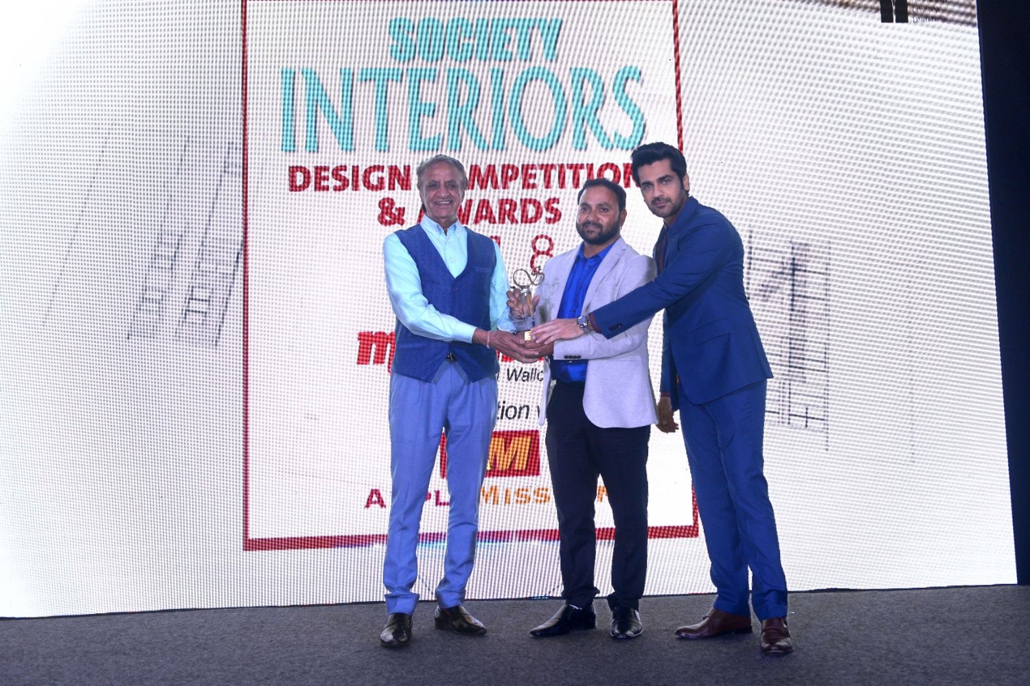 Pawan Kumar Bhatt receiving the award on stage in front of the Society Interiors Design Competition & Awards 2018 backdrop